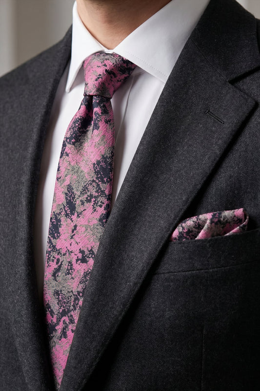 Koyu gri takım elbise ve beyaz gömlek üzerinde pembe gri batik kravat