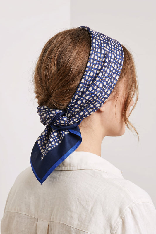 Keten gömlekli kadında saç bandı olarak bağlanan Milleniva lacivert fular, bandana stili modern kadın saç aksesuarları.